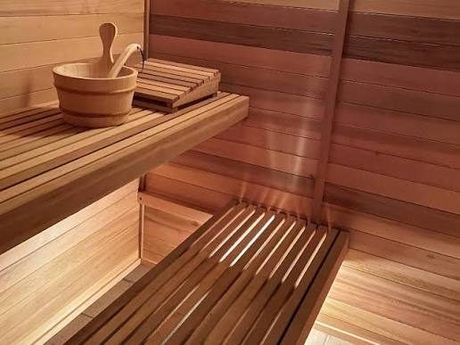 Cedar sauna benches with a wooden bucket and ladle