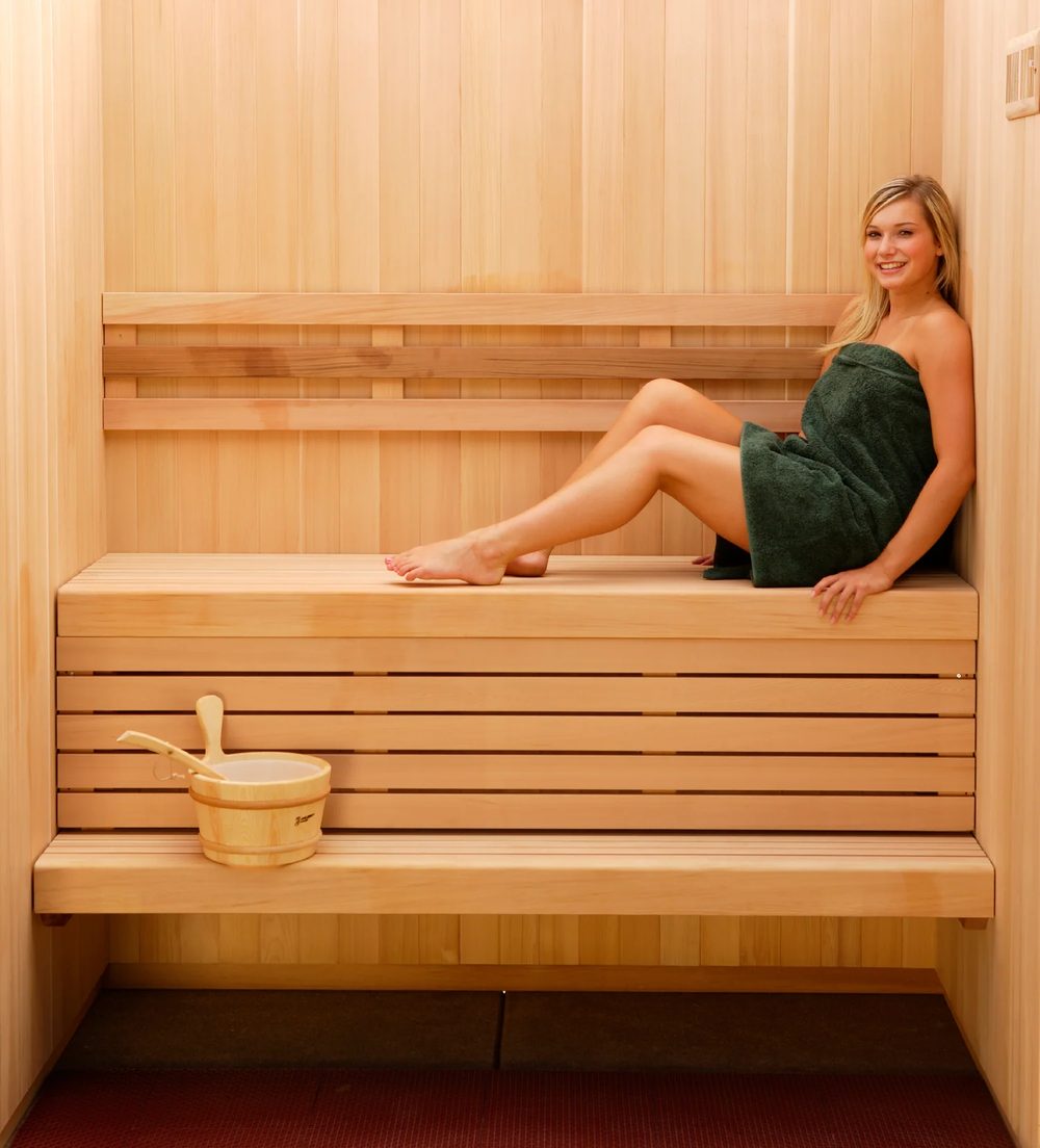 A guest relaxing on the cedar sauna bench